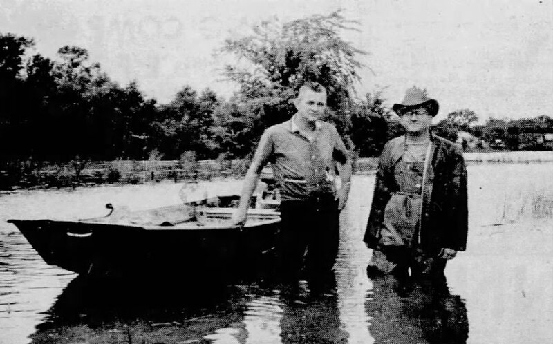 This photograph depicts Buddy Henagan and Dr. Harry L. Shaheen wading waist-deep in water after the DeQuincy flash flood of 1966.
