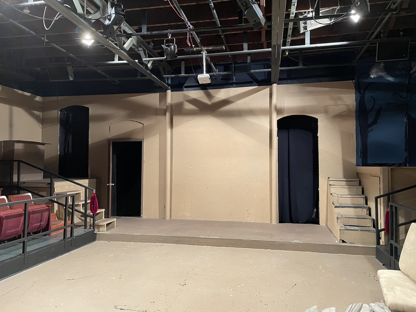 The unfurnished stage area with lights and side seating for the audience.